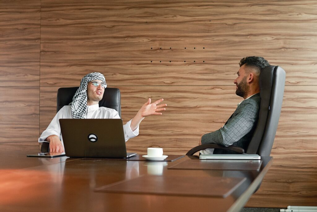 men sitting on office chairs while having conversation