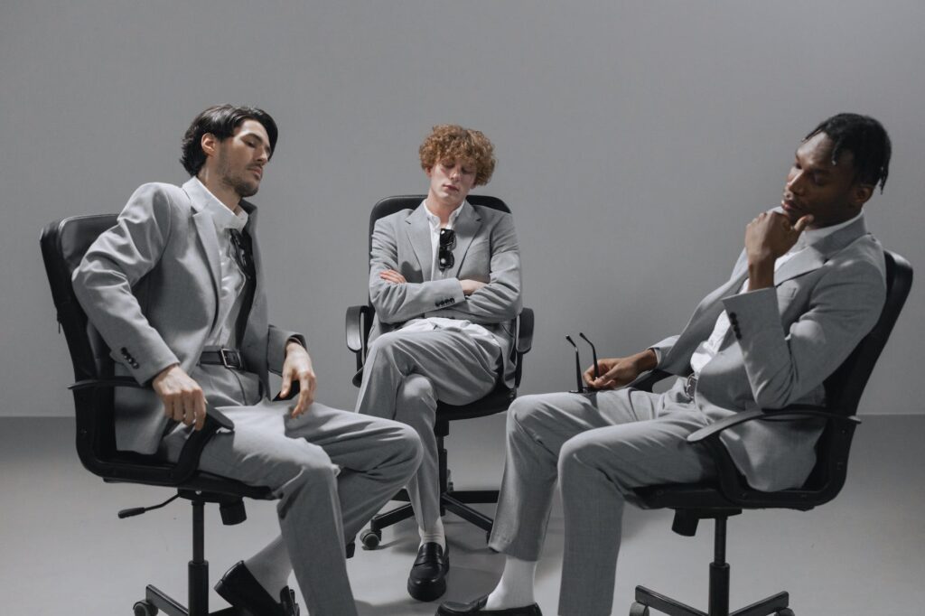 men wearing gray suits sitting on the office chairs